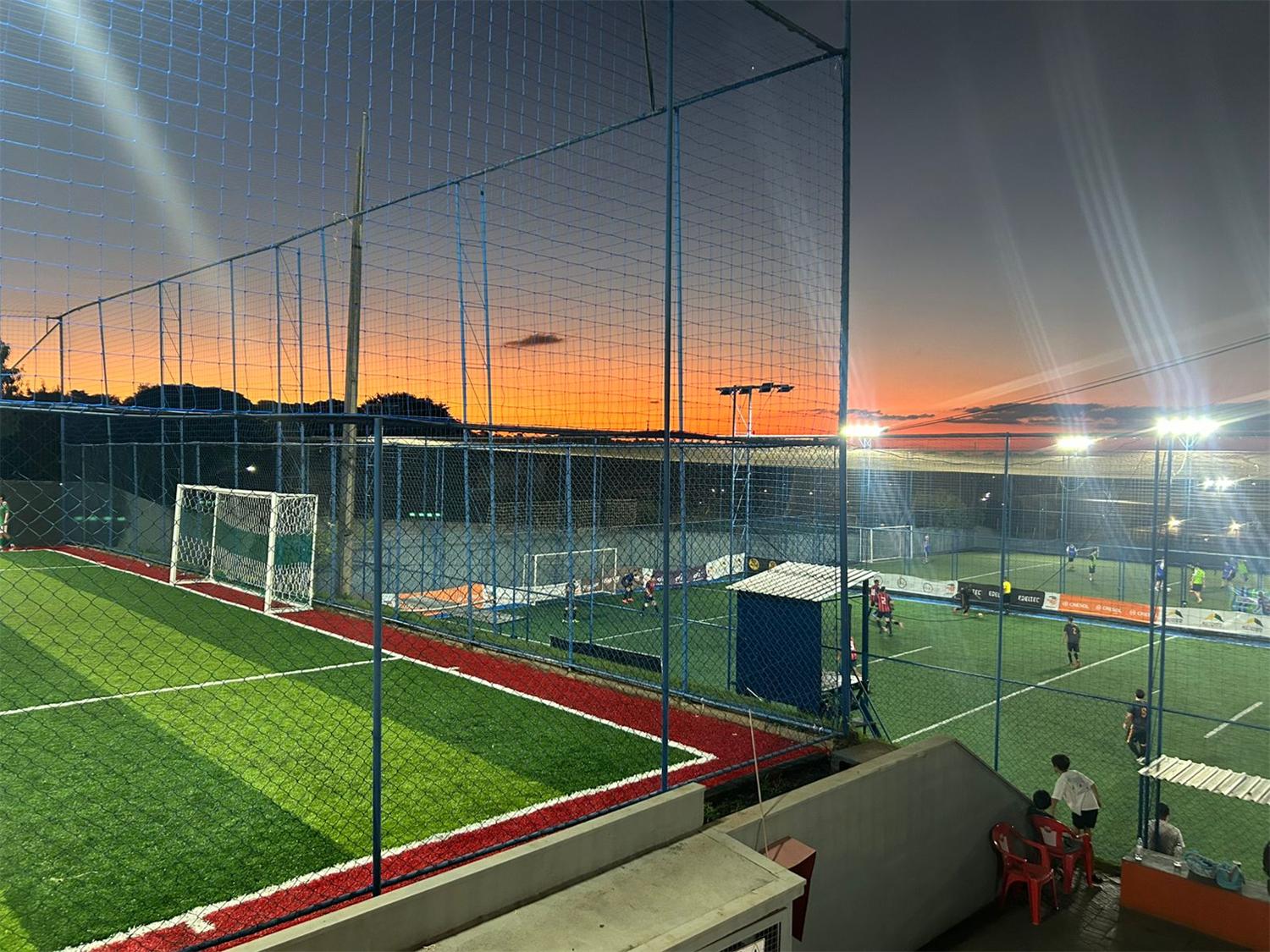 Nova Arena iluminada ao entardecer com jogos rolando